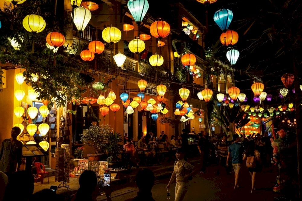 The lantern-lit streets of Hoi An Night Market create a magical, colorful atmosphere where glowing lanterns illuminate vibrant stalls 